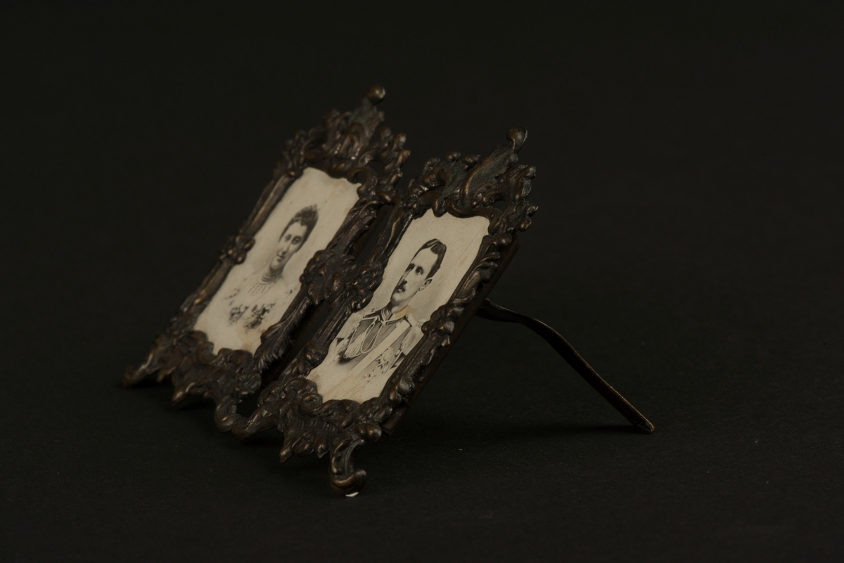 Två fotografiska miniatyrporträtt i metallram.
Porträtt av en kvinna och en man som är monterade i en tvådelad ram i nyrokokostil. Ramen har ett utfällbart stöd på baksidan.