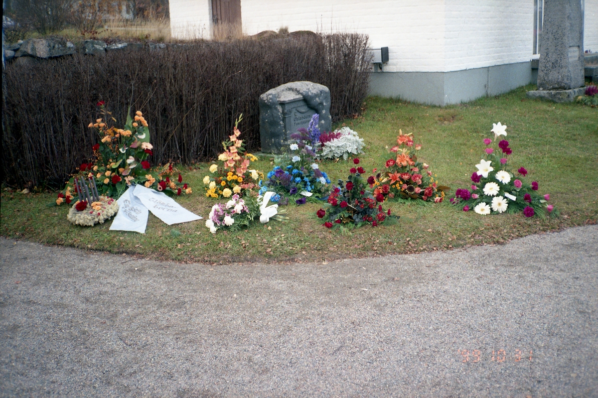 Blommor framför gravsten vid Rengsjö kyrka, 31 oktober 1999.