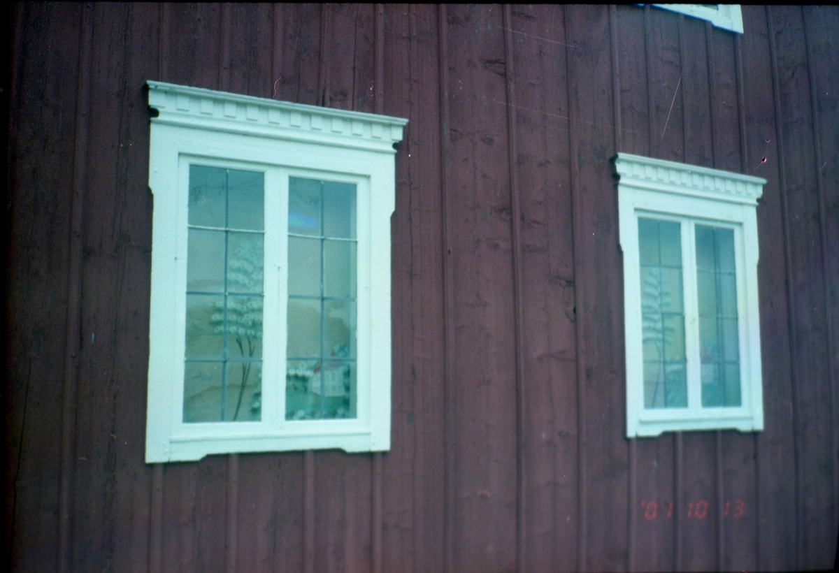 Trähus med spröjsade fönster där det hänger schablonmålade rullgardiner, 13 oktober 2001.