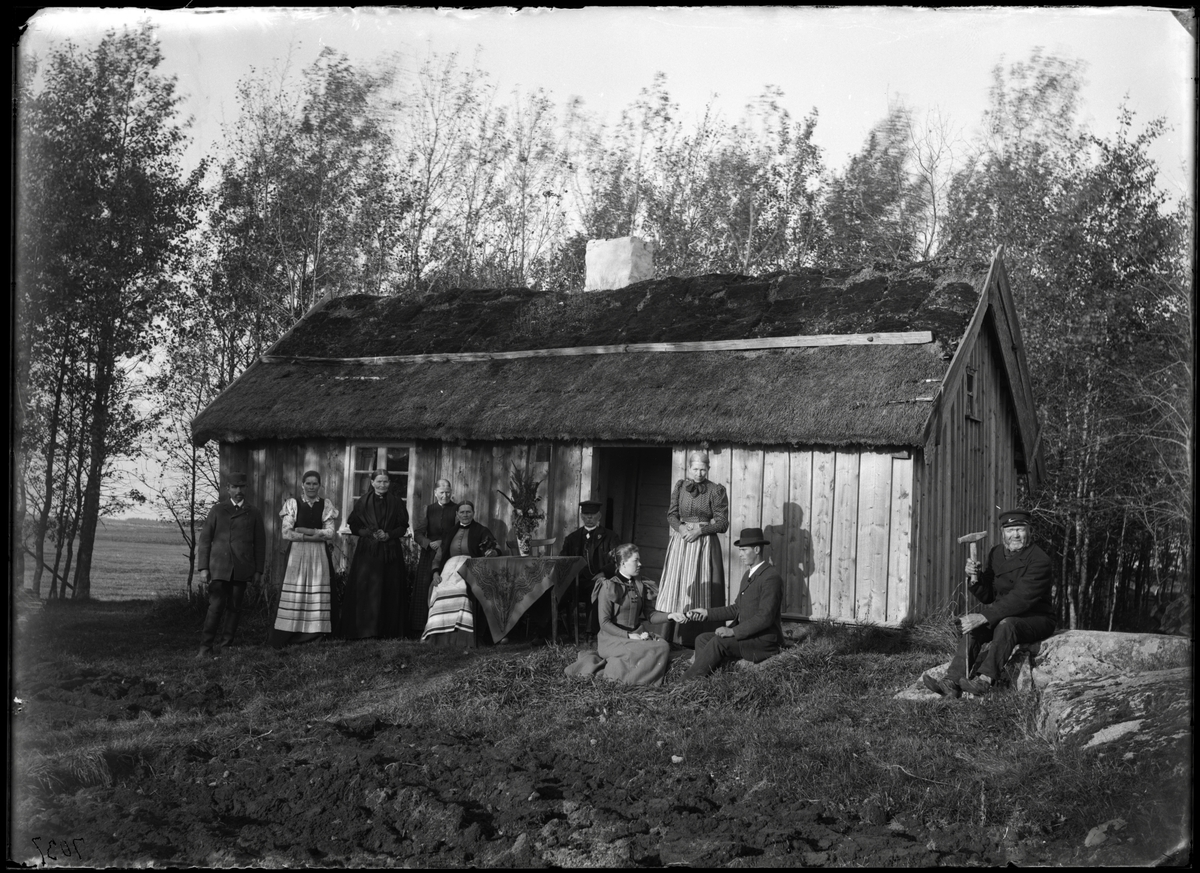Familj framför timrad stuga