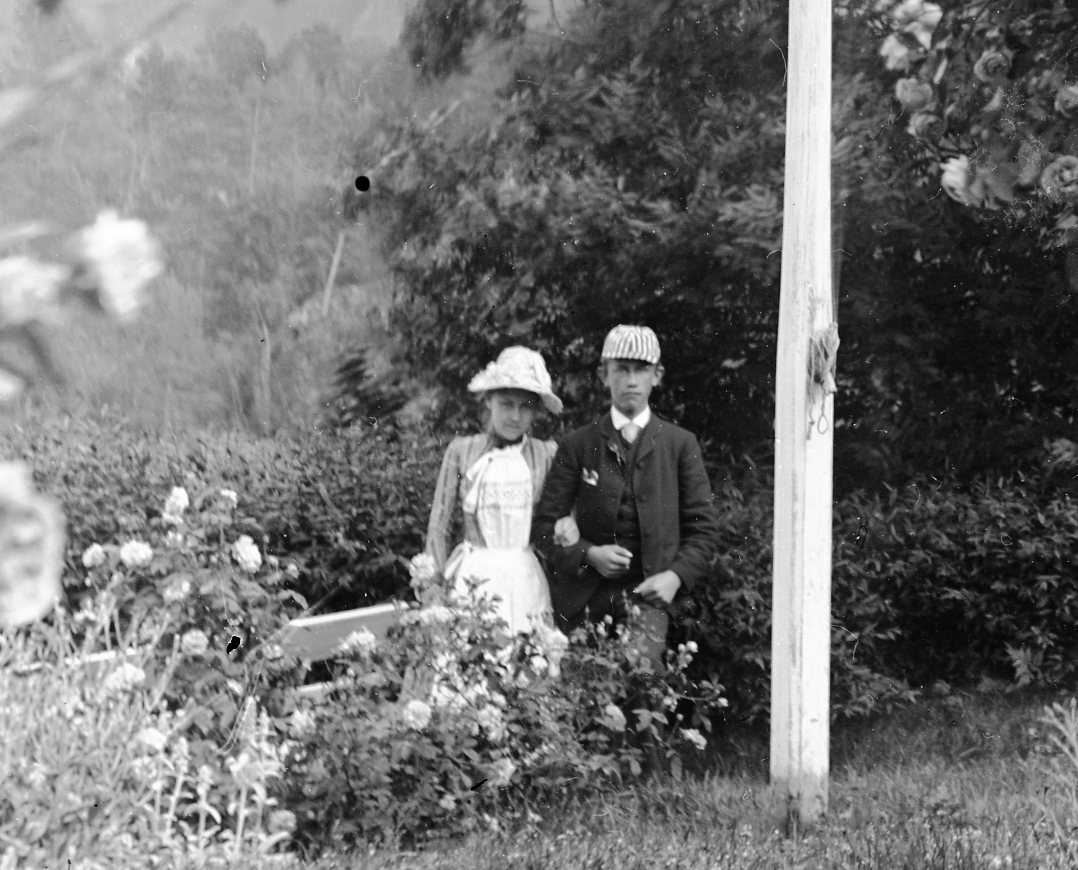 Caroline Fog ved stamrose, hund. Christian Murer og kvinne i bakgrunnen på Berg gård, Kragerø.