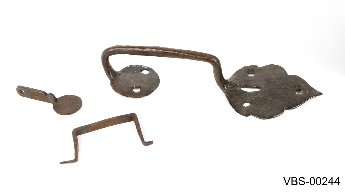 Låse- og håndtakssett bestående av fire smijernsstykker:

(a) Beslag med håndtak 
(b) Nøkkel
(c) Bøyle
(d) Tunge. Mangler.