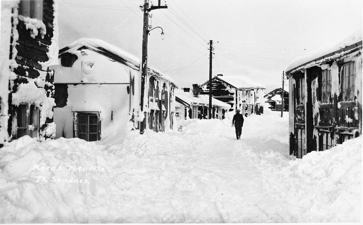 Øra, Røros. En person går nedover gata vinteren 1932. Store snømengder