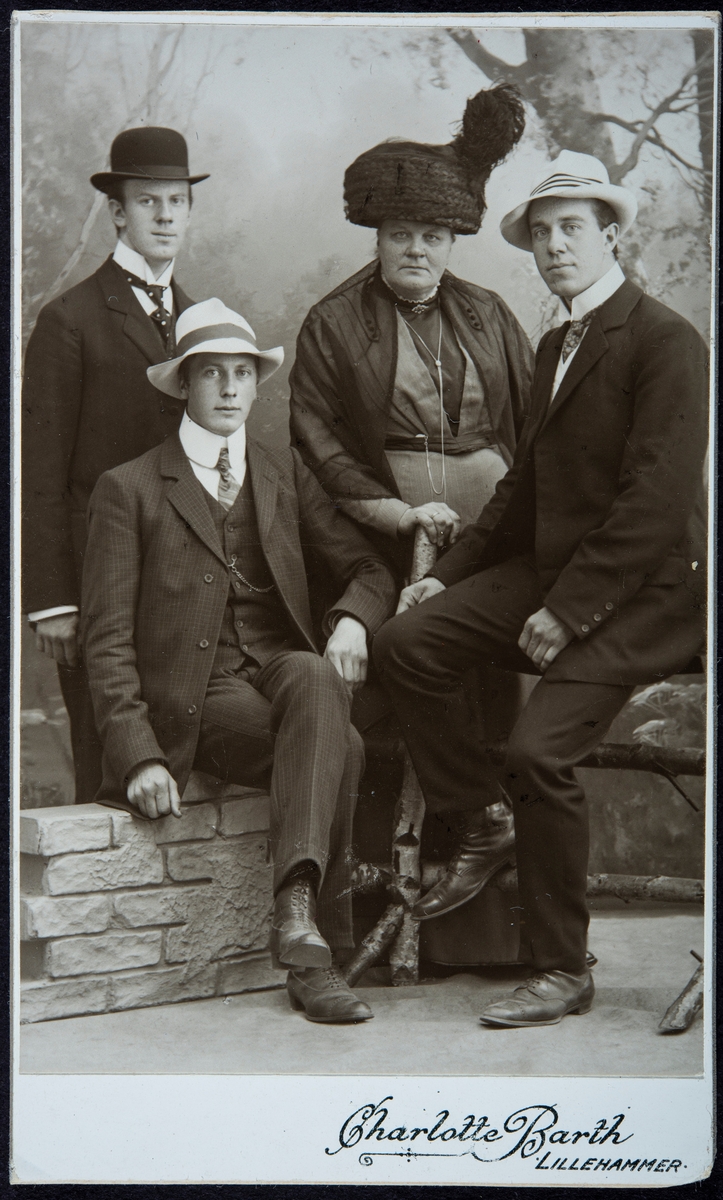 Gunda Smestad født Simenstad (1854-1931) med sønnene Georg (1880-1959) som drev Tandem handel fra 1913, Einar (1884-1964) somdrev butikken på Eriksrud fra 1913, og bak til venstre: Harald (1889-1912). Hun var enke 39 år,