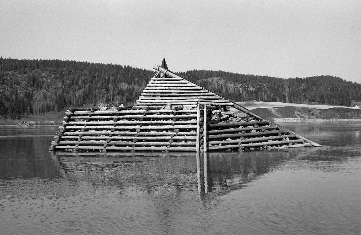 Fløtingskar i Glomma ved Bingen i Sørum kommune i Akershus. Dette er et såkalt «reierkar» eller «reiarkar», trolig et av karene som ble restaurert i 1968. Atholdslenseanlegget ved Bingen besto av drøyt 50 såkalte steinfylte tømmerkistekar som var forankret i pæler som var drevet ned i elvebotnen. Disse pælene og tyngden i steinmassene skulle bidra til å stabilisere lensekarene, som ble utsatt for stort trykk fra elvestrømmen og de enorme tømmermengdene som skulle holdes igjen her i påvente av ledig kapasitet ved sorteringsanlegget ved Fetsund, altså vid innløpet til innsjøen Øyeren, seks-sju kilometer lengre nede i vassdraget. Bildet er tatt under en befaring med Riksantikvaren.