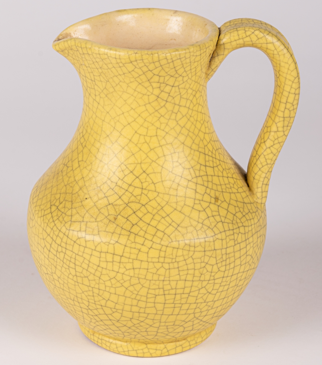Liten gul kanna med hänkel, modell 3480, glasyr 1533 - klargul matt antik konstglasyr (krackelerad). Formgiven av konstnär Eva Jancke-Björk 1944 för Bo Fajans, Gävle.