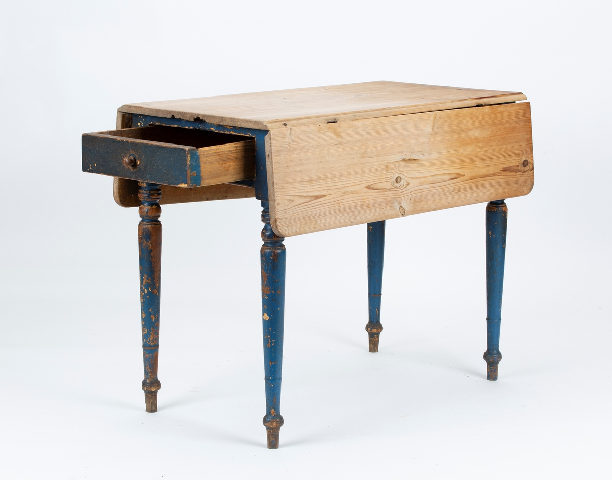 Klaffebord med trehvit plate, to klaffer og en skuff. Blåmalte ben. Kvadratisk med oppslåtte klaffer.