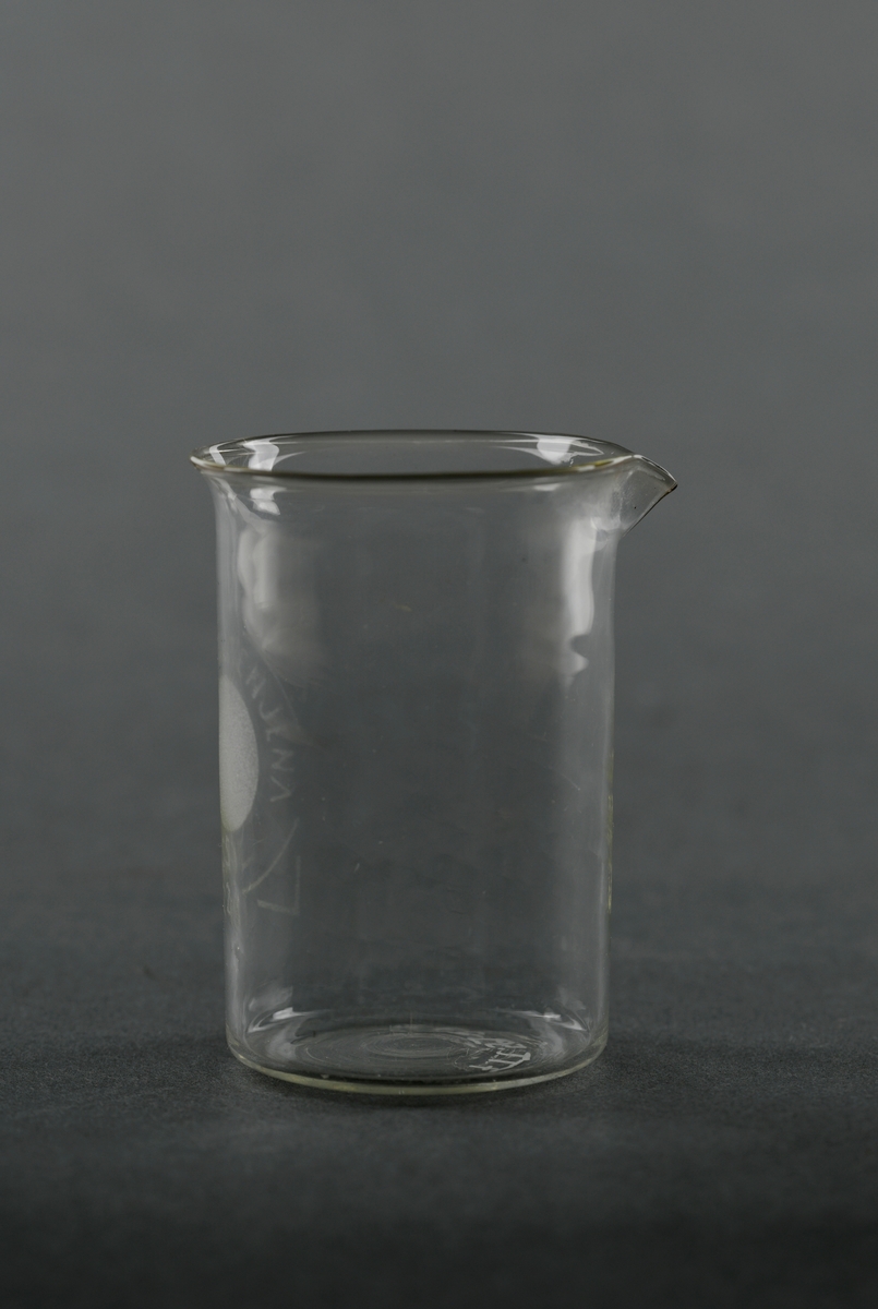 Et begerglass av borosilikatglass. Det er sylindrisk med en liten helletut oppe på kanten. Begeret er av typen "Schott Cenjena". Slike glass tåler høy varme, kjemikalier og temperaturforandringer og egner seg til kjemiske eksperiment og lignende. Det rommer 50 ml.