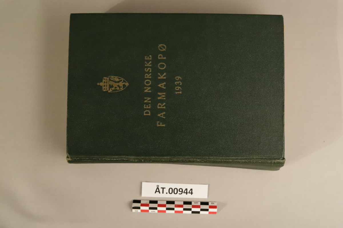 Mørkegrøn bok med gulldetaljer: Den norske farmakopø, 1939 (Pharmacopoes Norvegica Ed. V) Utgitt på offentlig opptak. I kommisjon hos H.Aschehoug & Co, Oslo 1939