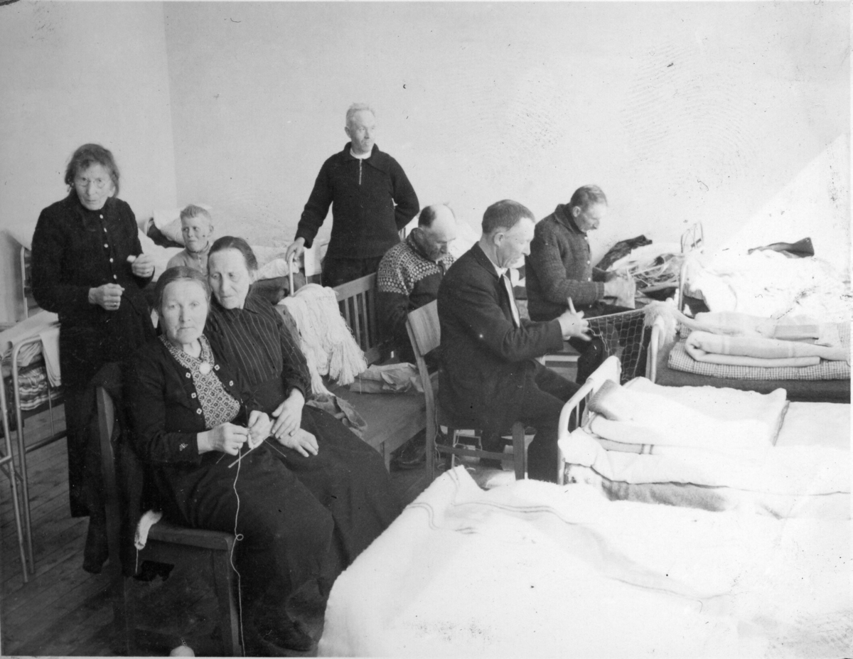 Storetveit skole i Bergen. Kvinner som strikker og menn som sit og bind garn ved nokre senger.