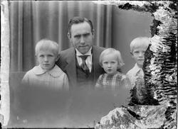 Portrett av Direktør Sandvold i dress og tre barn