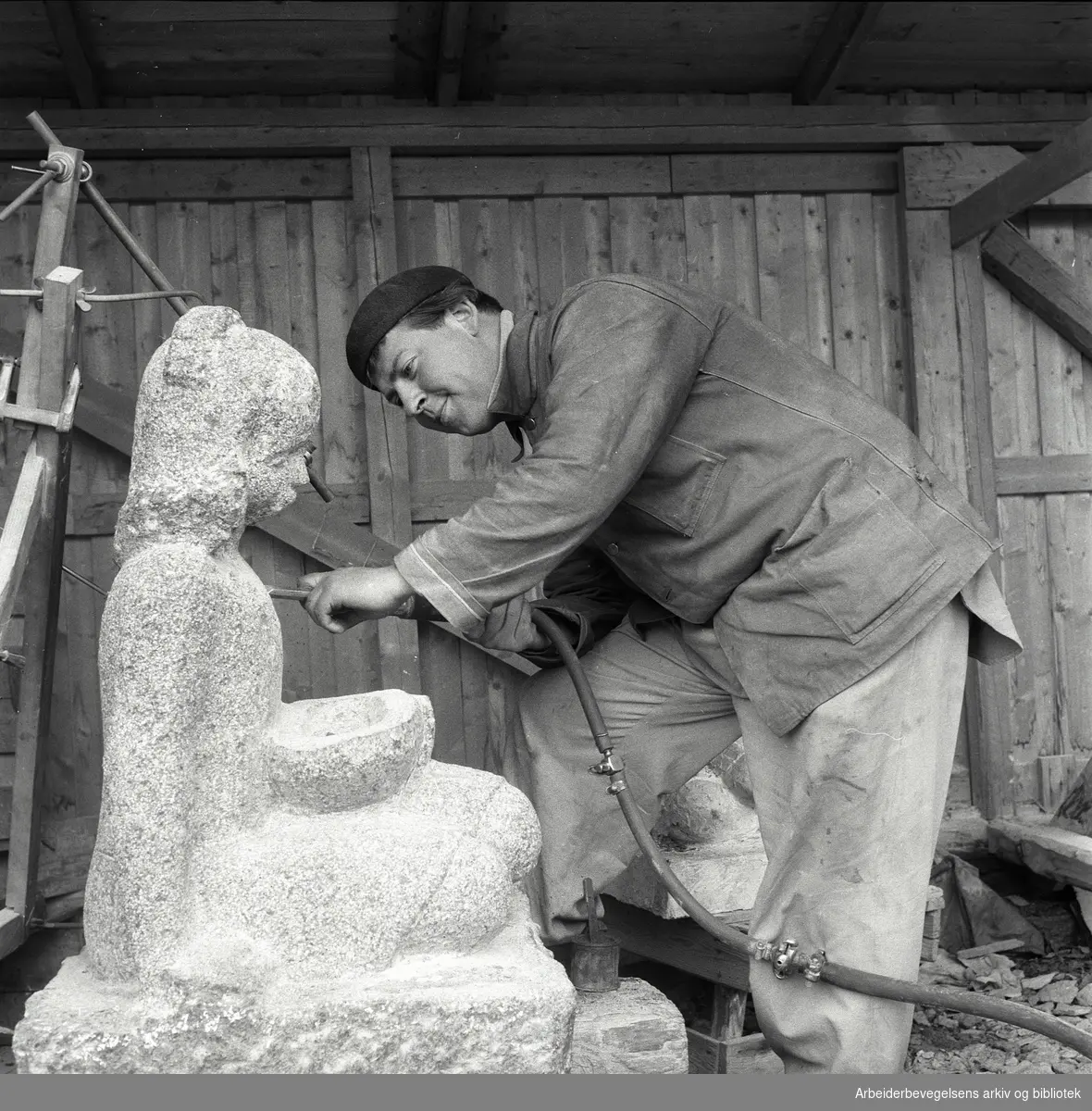 Norsk Billedhoggerforening og AL Steinskulpturs verksted på Helsfyr. Billedhugger Arne Vinje Gunnerud arbeider på en skulptur av Sigrid Welhaven. Juni 1957.