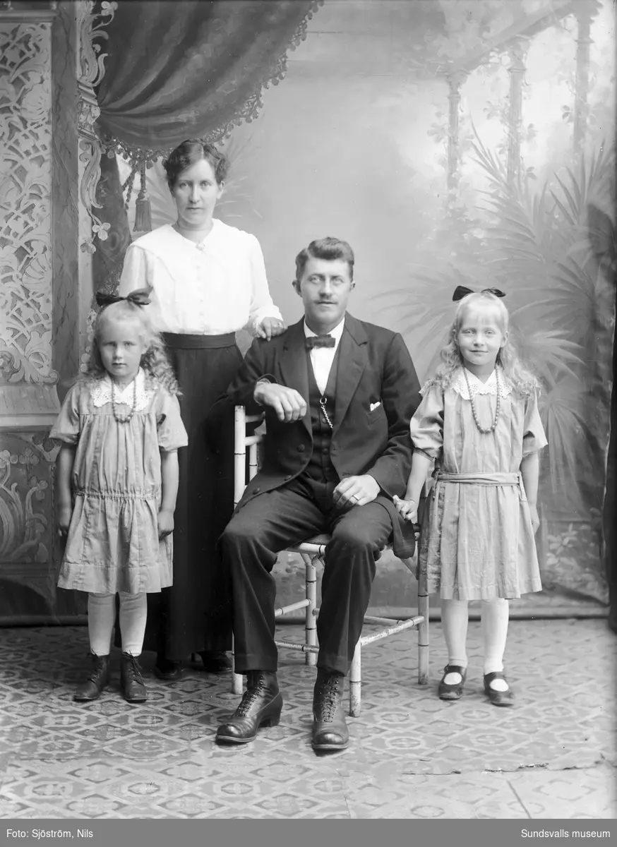 Ateljéporträtt, familjefoto med en kvinna, en man och två flickor.