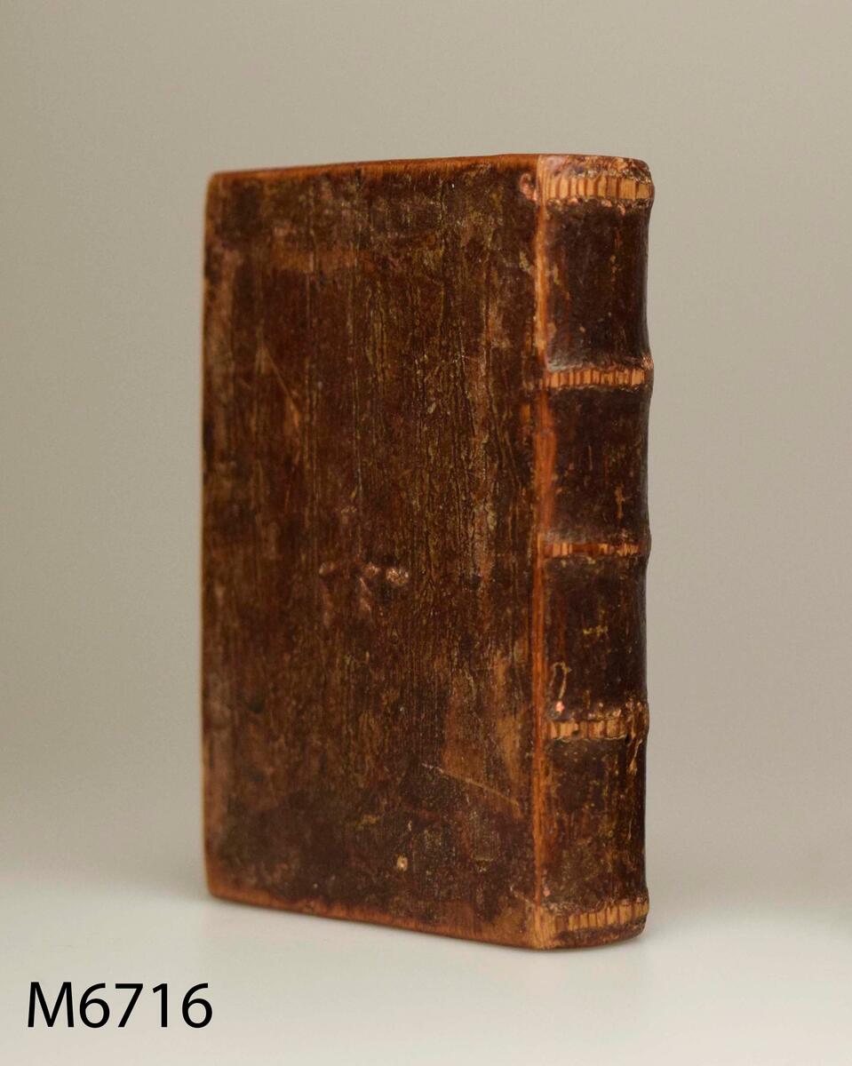 Almanacksfodral, av trä. I form av en bok i välskt band. Skjutlock har funnits men saknas nu. Fodralet målat i brun färg, märkt på ena sidan: 1757, på den andra t? Hädanberg, Anundsjö socken, Ångermanland. 