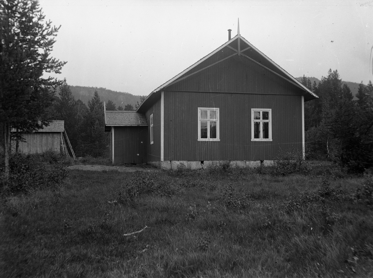 Fotosamling etter Kjetil Skomdal (1881-1971). Fotografen virket i perioden 1910 til 1960 og hadde eget mørkerom hvor han også tok imot film fra andre fotografer. I perioden var han også postbud i Fyresdal. Bildet viser enkel stue. Motiv med hus.