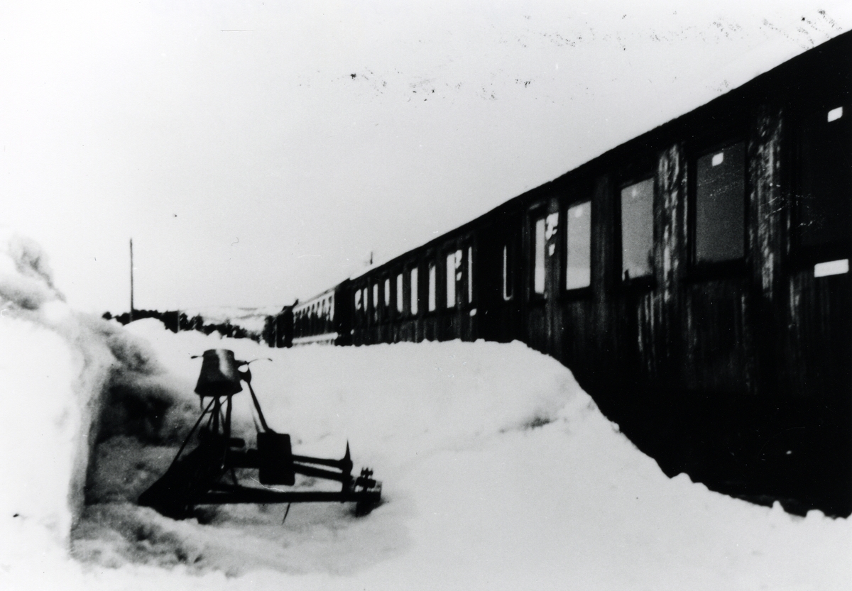 Setesdalsbanen. Hornesund. Snørik vinter, passasjervogner og endresin med spade står langs toget. Årstall ca 1952.
