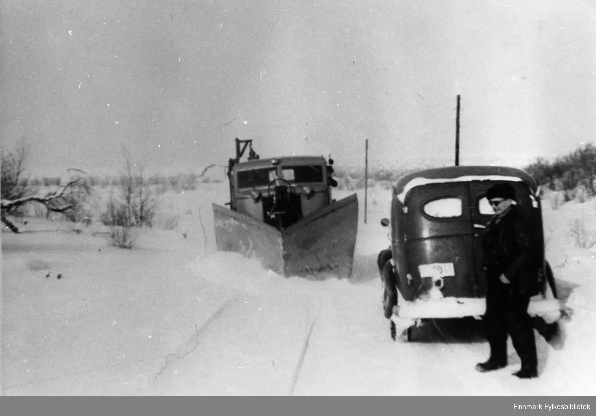 Brøyting. Bildet tatt på landeveien, landskapet ligner på Seidafjellet. Personen på bildet er veioppsynsmann, Kristian Alexandersen, fra Hammerfest. Varebilen ved siden av brøyta er en Chevrolet anno 1946-1947. Brøytebilen er fire-hjulstyrte FWD SU-COE.