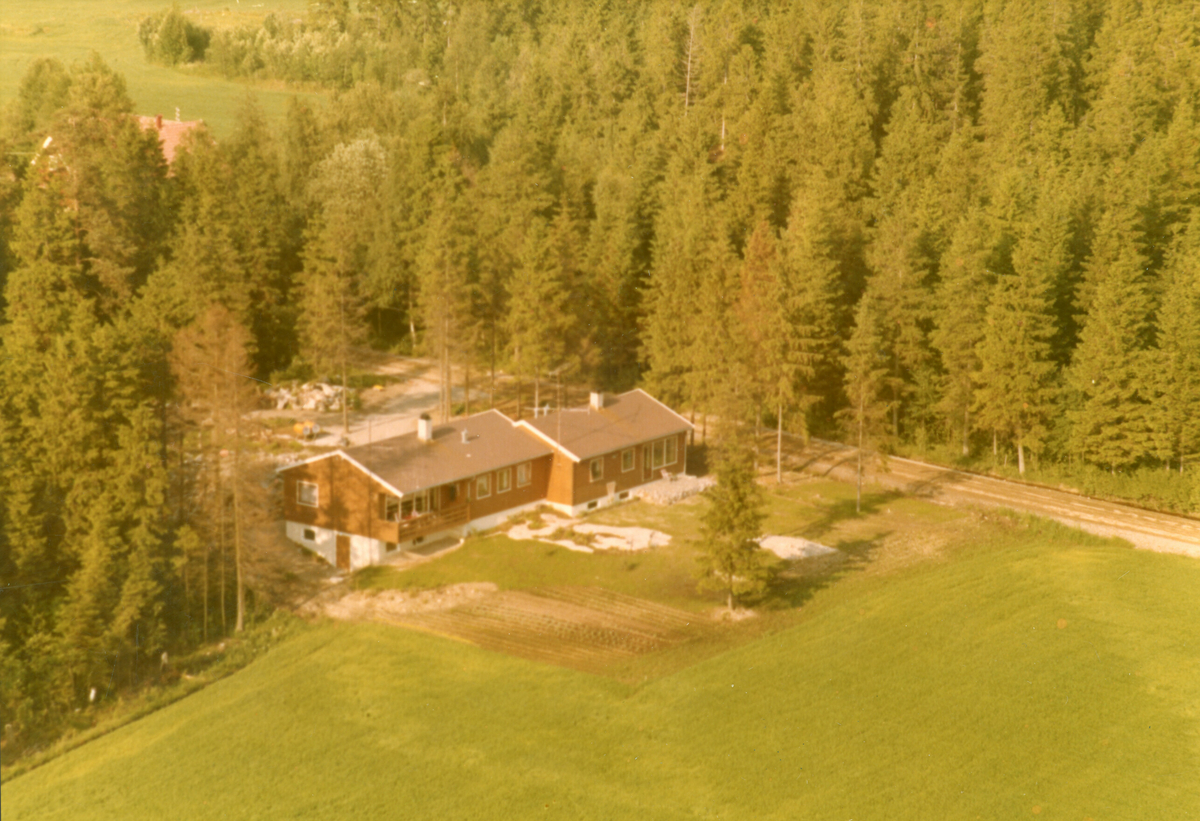 Flyfoto av hus i skogkanten.