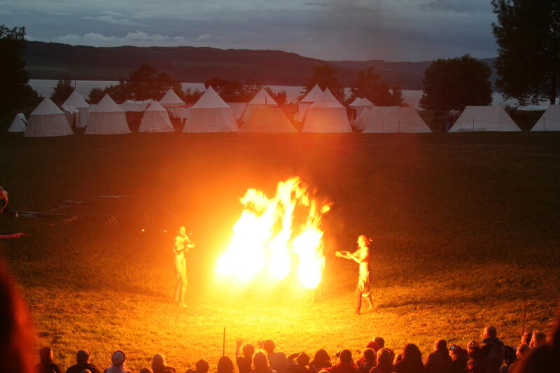 Gycklargruppen Trix utfører flammeshow i mørket, i bakgrunnen ses en leir av middelaldertelt.