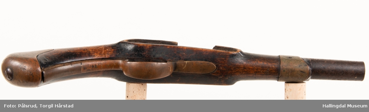 Kavaleripistol (rytterpistol), opprinnelig med flintlås. Mangler i dag låsen og ladestokk. Skjeftet er kuttet rett foran et messingbeslag. Messingbeslag på kolbe. Modell fra 1818, produsert på Kongsberg våpenfabrikk. Denne modellen hadde opprinnelig en løskolbe som kunne skiftes.