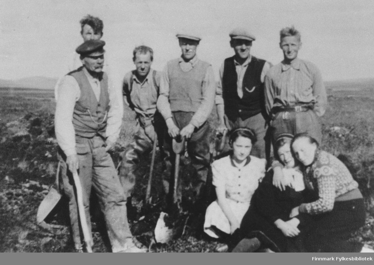 På dette bildet ser vi Hans Andersens veganlegg i Olderfjord-Skaidi, "Hatter", ca. 1935. Fra venstre: Hans Andersen (formann), bak ham en ukjent mann, Ingolf Holmgren, Hjalmar Johansen, Henry Holmgren, Mathis Monsen. Tre kvinner som sitter foran er ukjente.