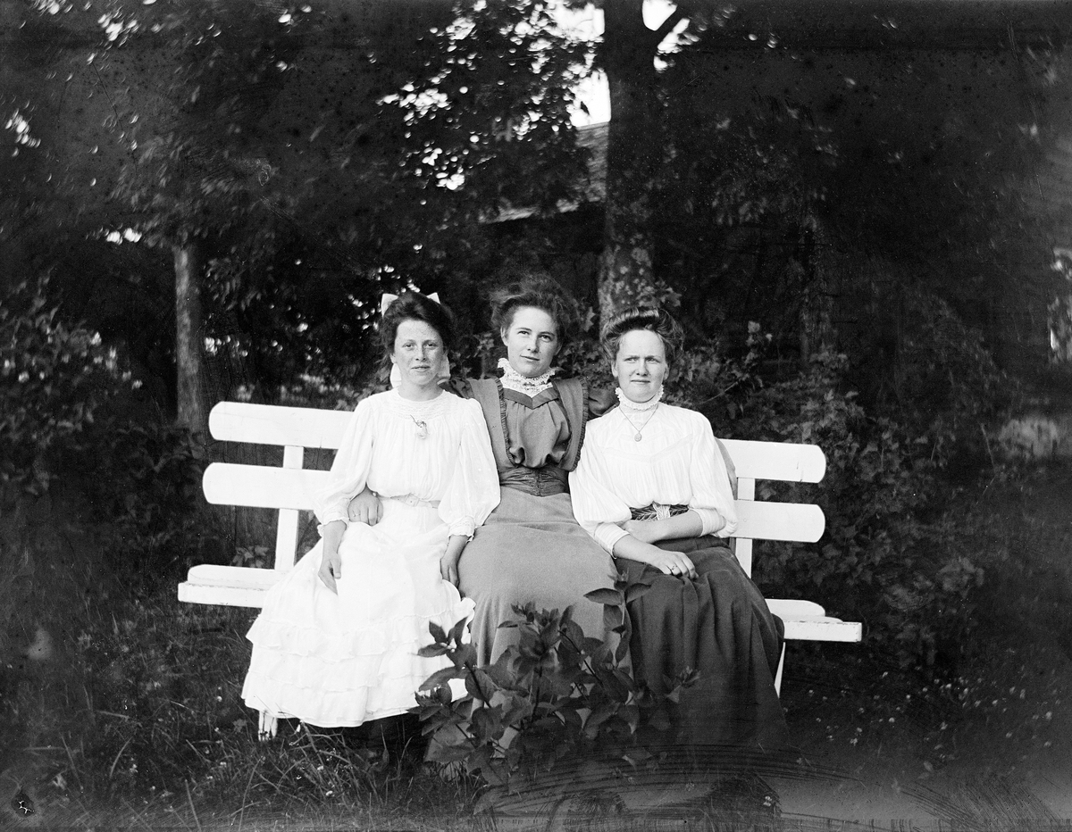 Tre kvinner på en benk.