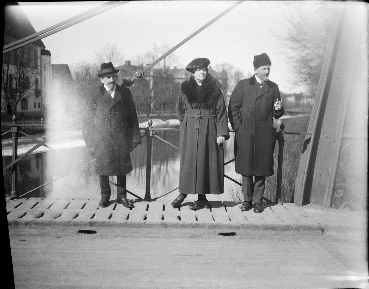 Tre personer står på Järnbron, Uppsala påsken 1923