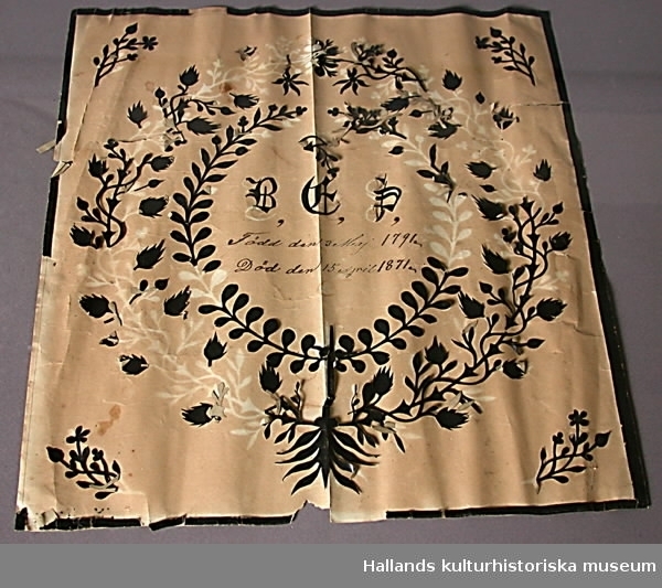 Dödstavla med svart silhuettklipp vilket bildar mönster med växtslingor och en krans. I mitten av kransen står det: "B...S...1791...1871".