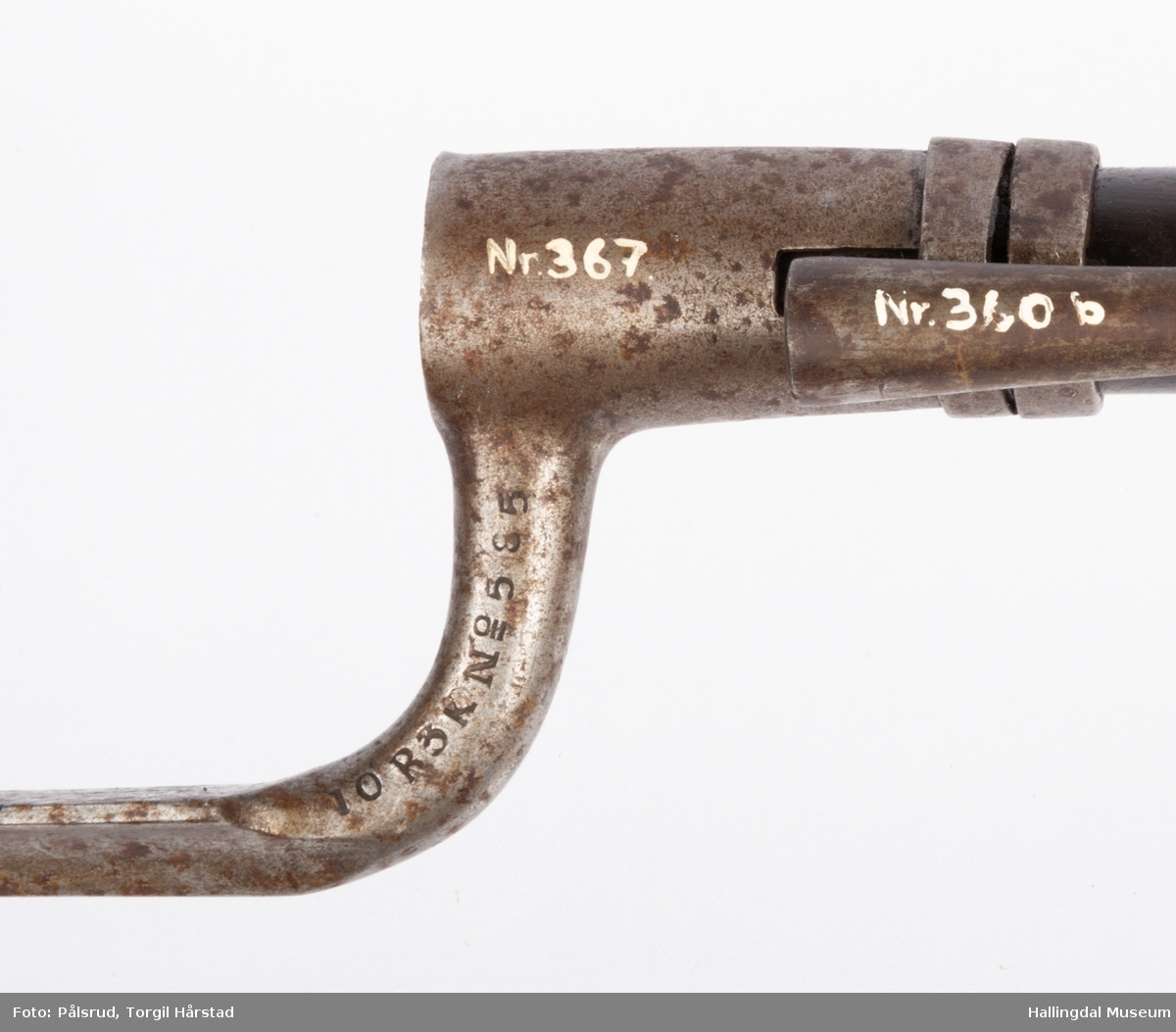 En dølle- eller hylsebajonett i stål. Festes på geværløpet (geværet har inventarnummer HFN 360 a-c) med en hylse og en metallring som festes med en skrue.