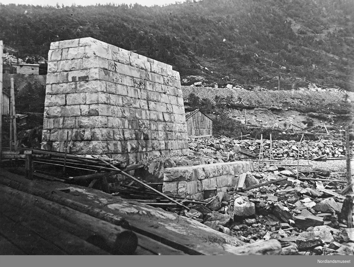 Muring av malmkai 1 i Narvik er påbegynt. En pilar er ferdig. En del materiale vises til høyre og i forgrunnen.