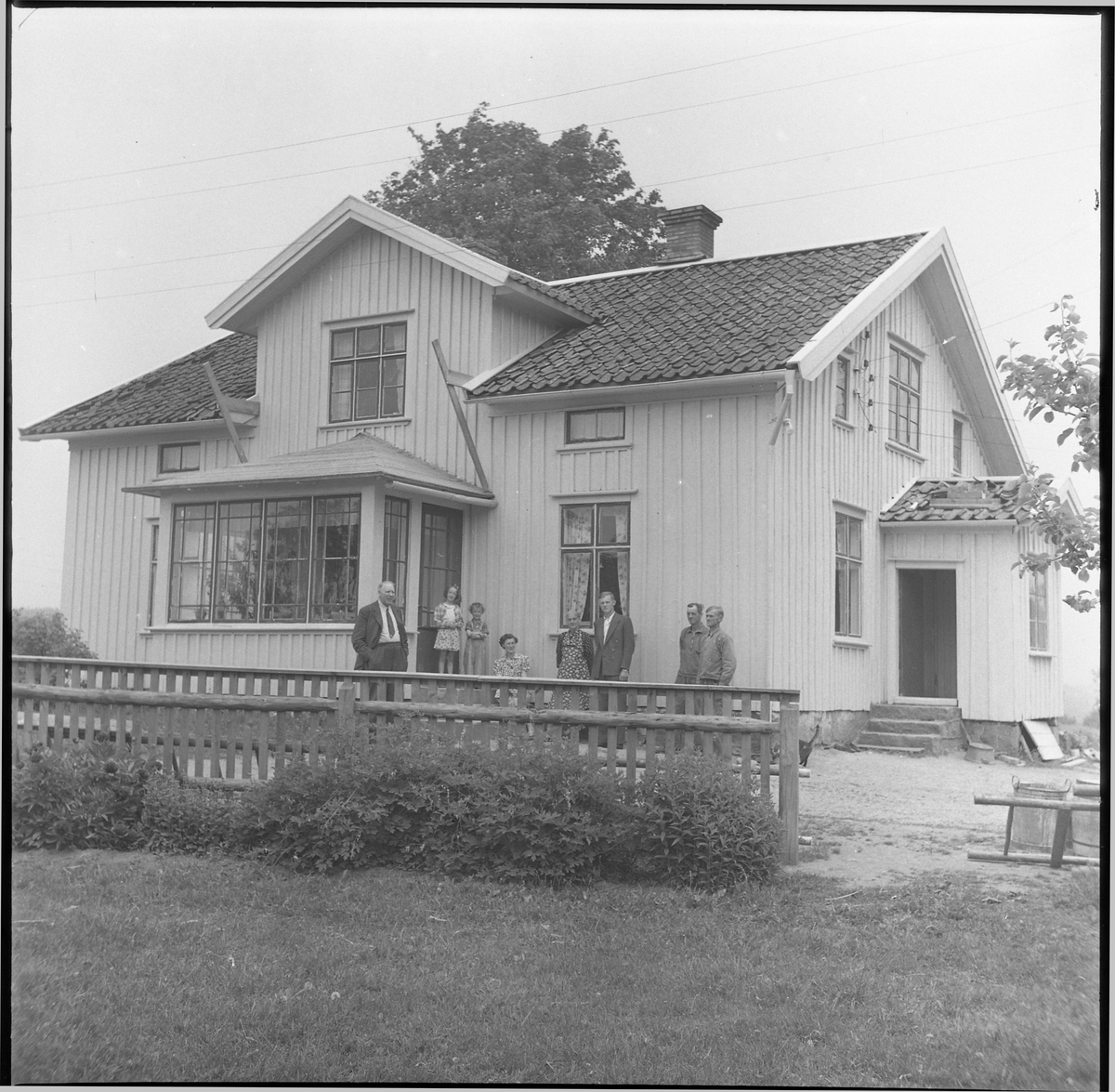 Barn och vuxna utanför en oidentifierad fastighet, juni 1950