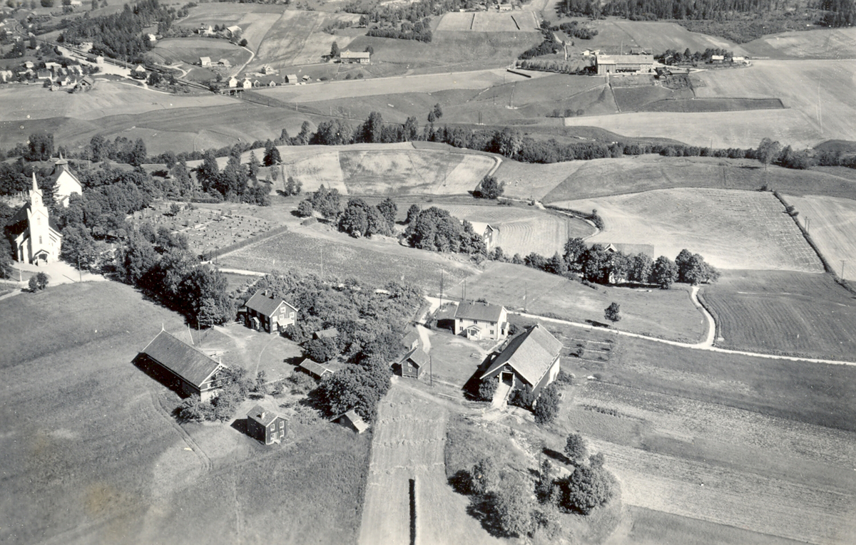 Flyfoto av Bøhaugen med kyrkjene og Bø-gardane (Midt-Bø), tatt 5. juli 1952.