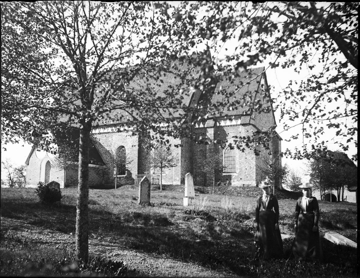 Två kvinnor vid Vendels kyrka, Vendels socken, Uppland
