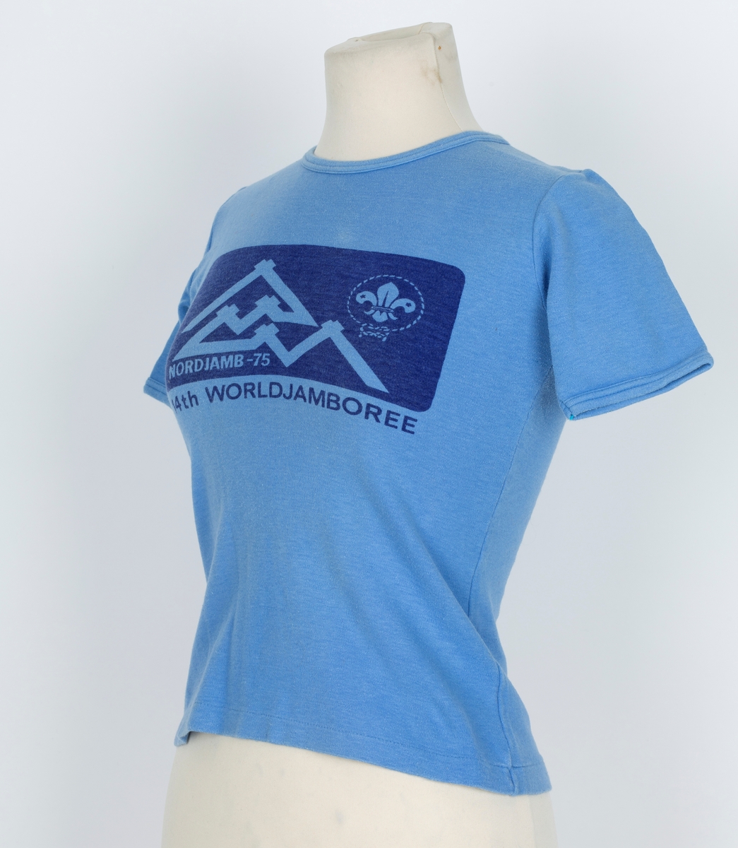 T-skjorte. Blå. påtrykt mørk blått felt på brystet, telt, speiderlilje, Norjamb 1975. 14. world jambore
Antatt brukt av sønne Jørn f. 1960
