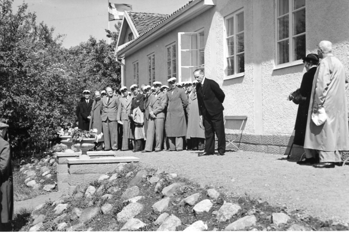 En man med hatt i händerna håller ett tal framför Vättermuseet i ...