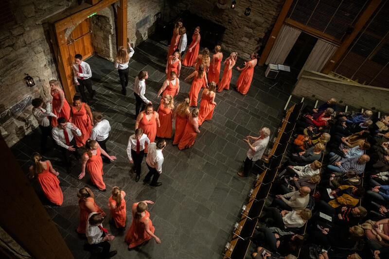 Bilde fra takhøyde ned på scena i Aulaen på Domkirkeodden der Defrost Youth Choir står og holder konsert. (Foto/Photo)