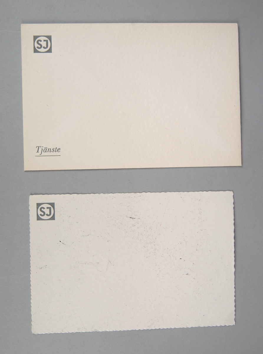 Rektangulärt kuvert (:1) och brevpapper (:2) av vitt papper. Uppe i vänstra hörnet finns SJ:s logga tryckt i grått. Nere i kuvertets vänsta hörn står det "Tjänste" i grått.