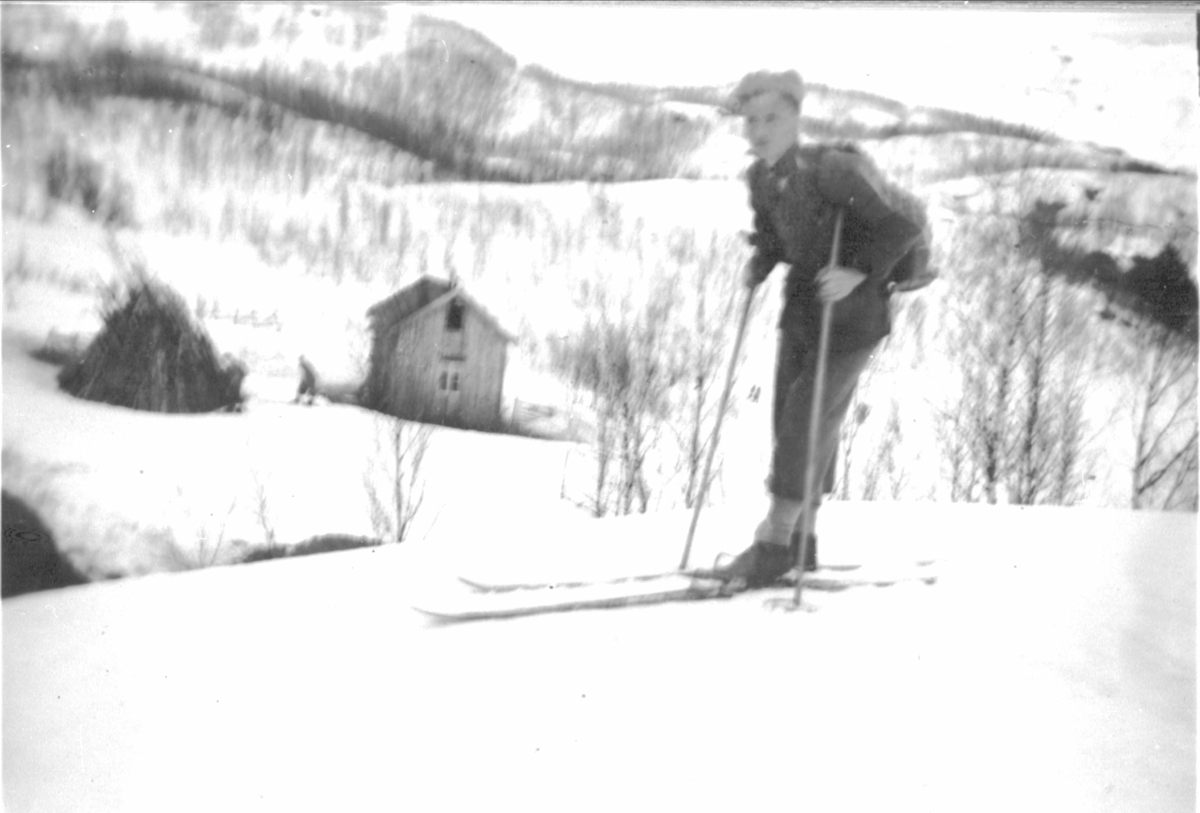 Mann på skitur på Blåfjell i Skånland. Hus i bakgrunnen.