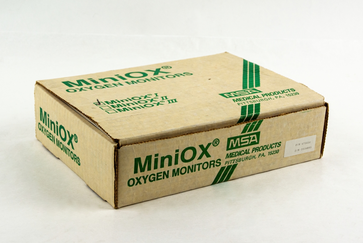 Syrehaltsmätare Miniox I, tillverkad av MSA medical products Pittsburgh USA. Förvaras i låda med tillhörande delar, manual och artiklar om flygande sjukvårdare.