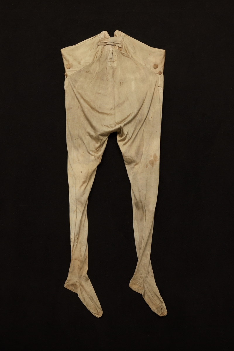 Benkläder tillhörande Gustav III:s daluniform.  Av beige sidentrikå. Fodrade med vitt siden till knäna.