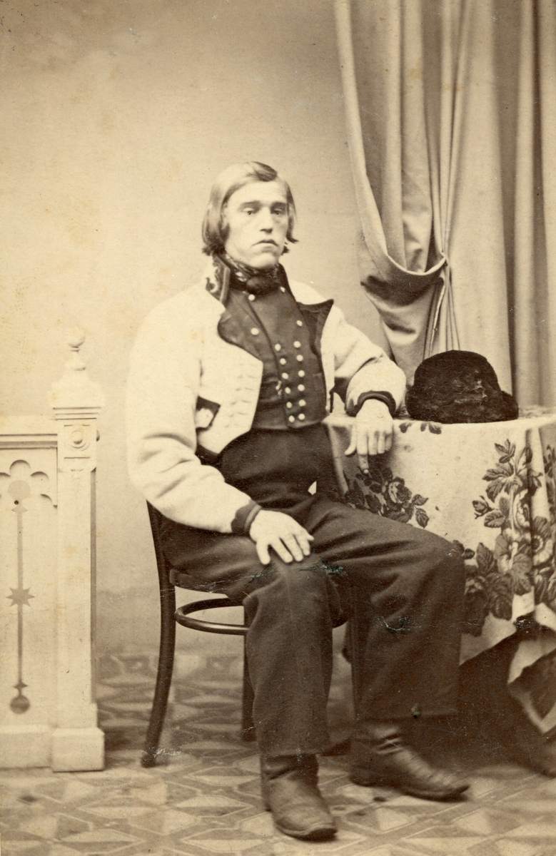 Halvor Fossheim (1837-1868) i gråkufte i atelier