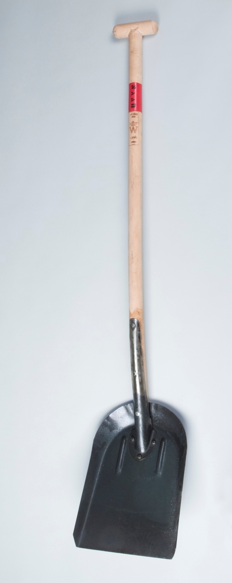Skyffel med skovel av järn och långt obehandlat träskaft med tvärgående svarvat handtag. Skovelbladet har rak framkant och uppböjda kanter baktill och på sidorna. Skovel och skaft är framtill fastnitade i varandra med järnskoning.

På träskaftet finns inbränd stämpel för Wedevågs bruk. Skaftet har upptill ett rödmålat band med bokstäverna "SAAB" i svart färg.