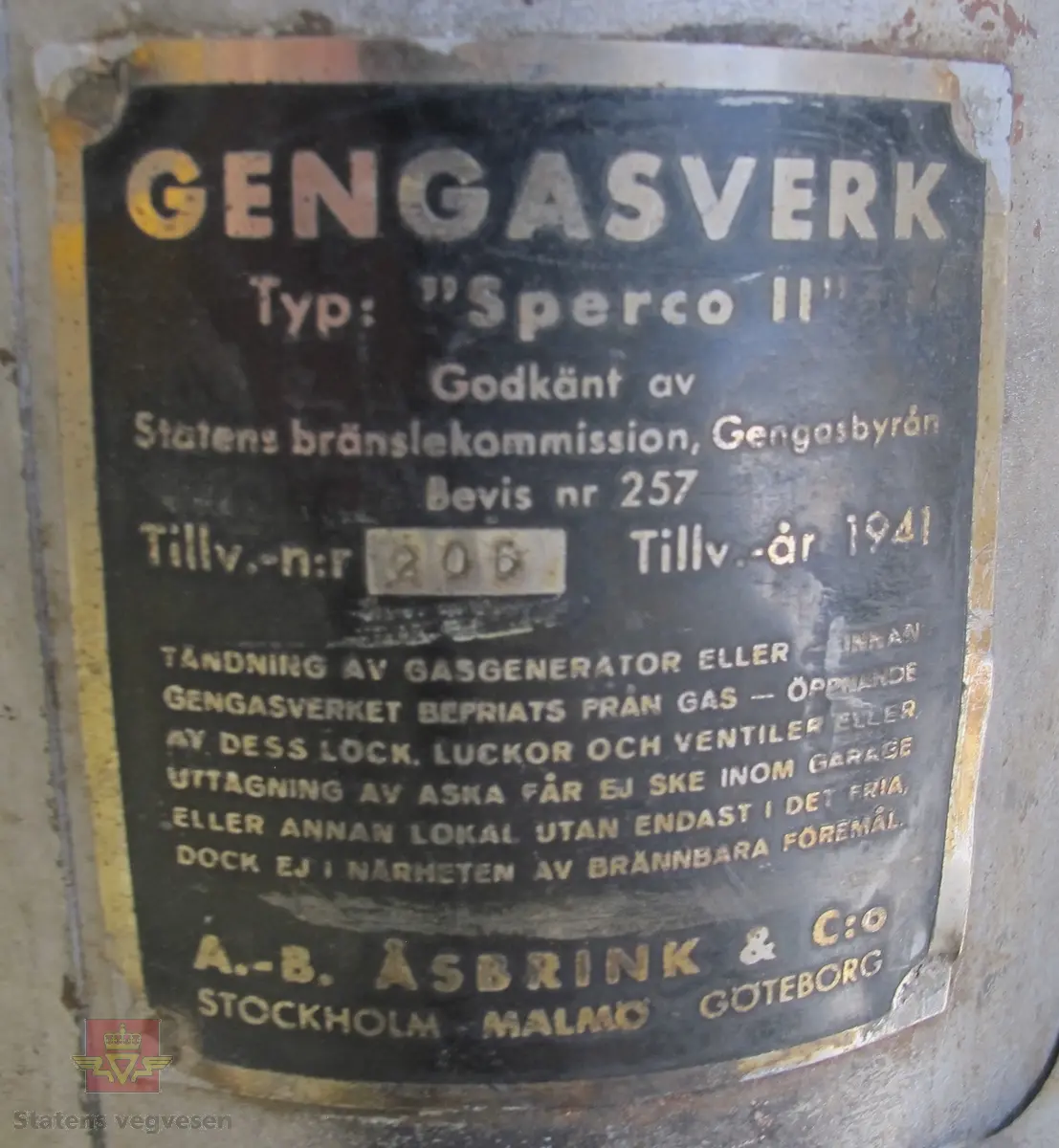 To sylinderformet tanker/beholdere/generatorer med flere luker montert på motorsykkel. Generatoren har et eget eksosanlegg som går fra den ene tanken. Den er også utstyrt med et brannslukningsapparat. Virkningsgraden er ca 0,4 med "godt køl", det vil si en 2,5 hk motor kan under gunstige omstendigheter teoretisk utvikle ca 1 hk. Kullet skal knuses til biter av størrelse 5-15 millimeter, og oppfyringen er svært omstendelig. I teorien skal man kunne kjøre ca 10 km på "en fyring".
