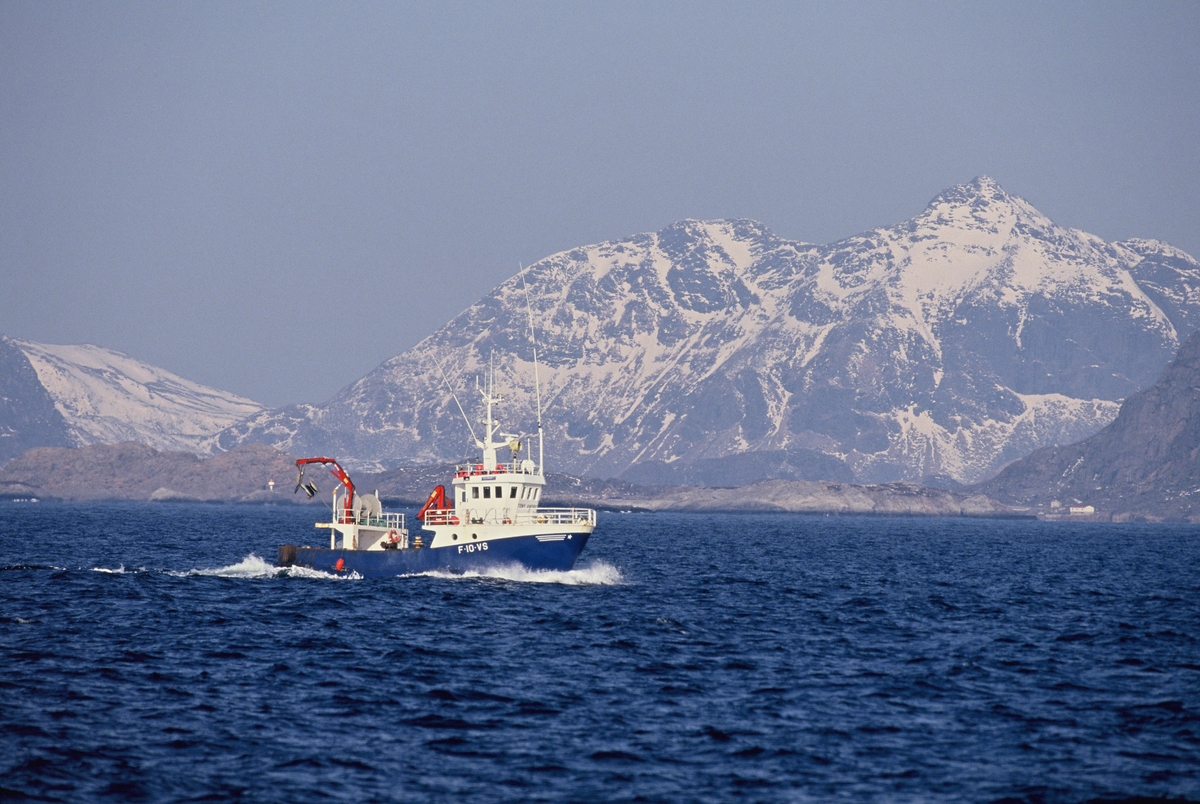 Fiskebåt på havet, Lofoten, med Lofotveggen i bakgrunnen