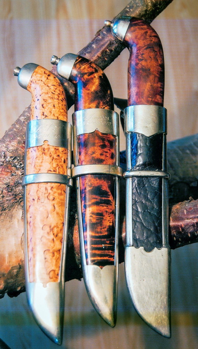 Tre Stensåskniver laget av knivmaker Otto Stensåsen. De to fra venstre har både skaft og slire som er laget av valbjørk. Kniven til høyre har, som alle Stensåskniver skaft av valbjørk. Beslagene er i nysølv.  Foto Bjørn Vidar Lindholt, Privat eie.