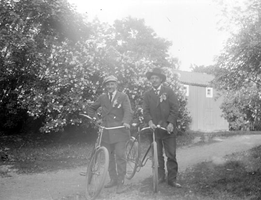 Grupporträtt, två män med cyklar.