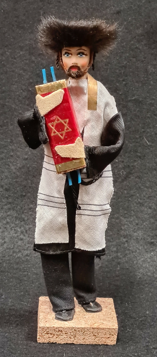Docka som tillhör Vera Hanssons docksamling.

Köpt 1980. Moshe, Israel. Asien. Judisk rabbin i svart klädnad. Pälshatt.