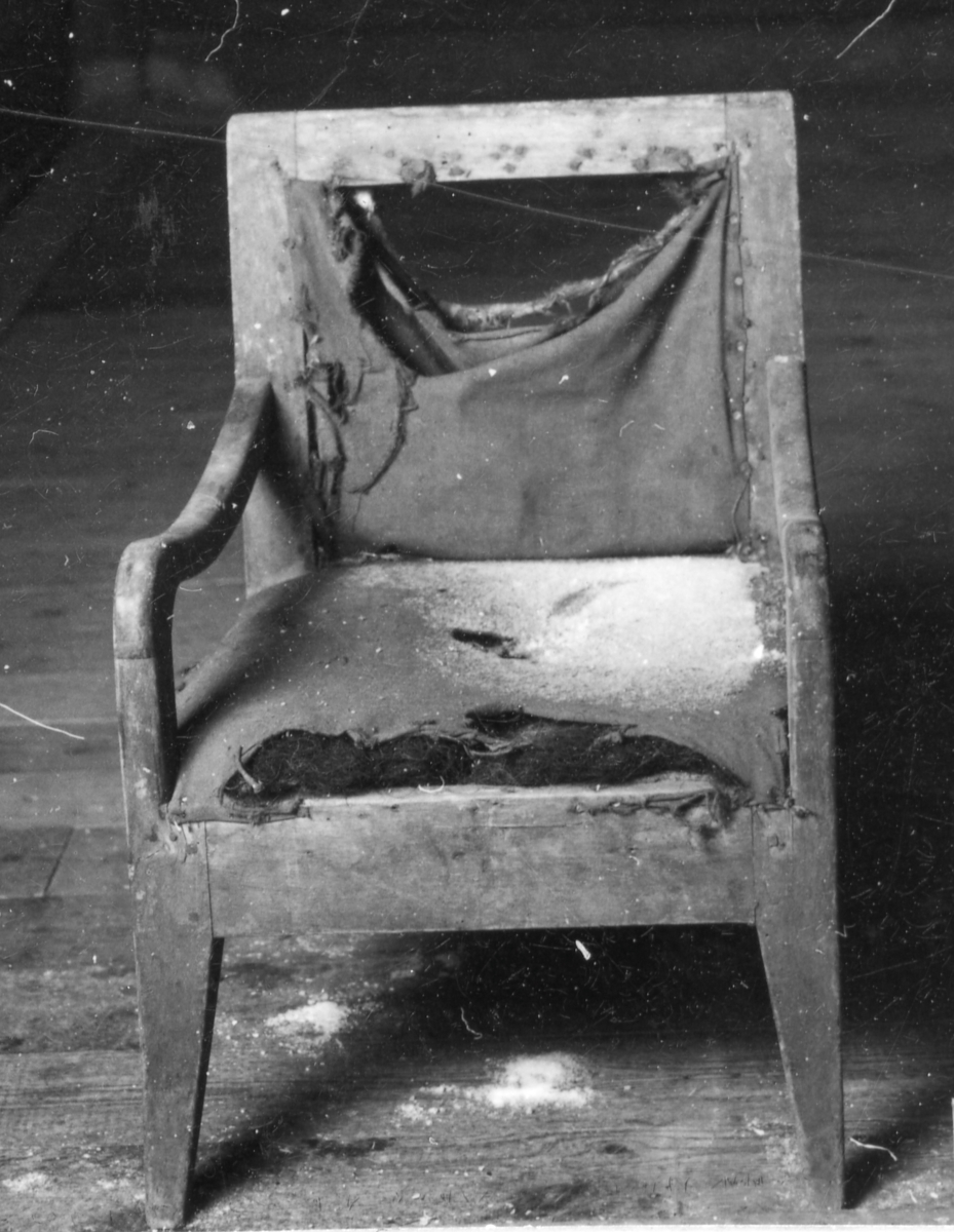 Brunmålad barnstol med sits och rygg stoppad med tagel och klädd med brunt bomullstyg. Svängda armstöd, konade ben.