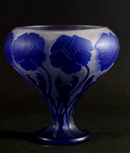 Av överfångsglas, starkt blå blommor mot vit botten. Signerad: "Kosta, månskära, KL, 104".