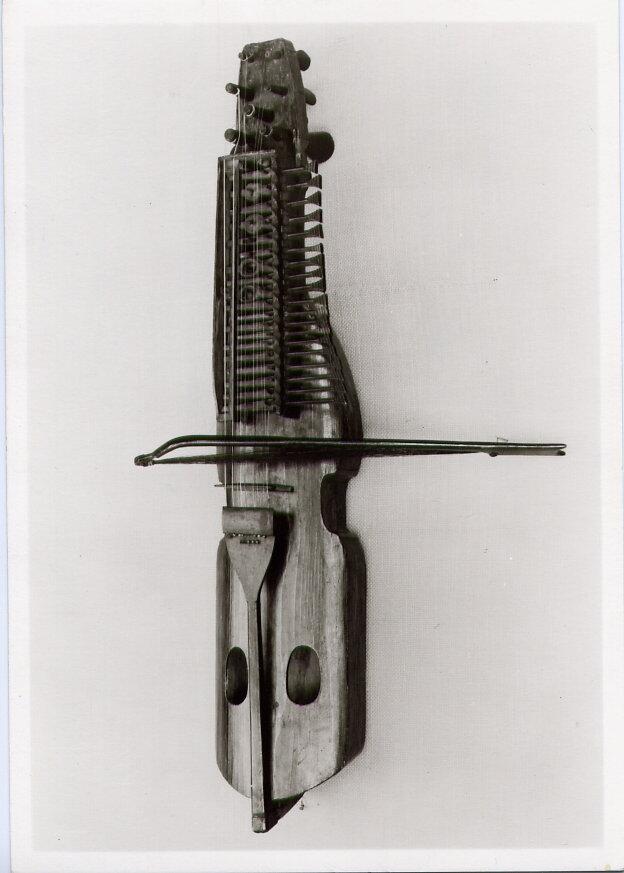 "Nyckelharpa av trä, som inv. 3177, med stråke hemvävt axelband. - Längd 90 cm. Stråkens längd 46 cm. (ur lappkatalogen, Arvid Enqvist 1936)

Nyckelharpa av furu med klaviaturlåda, nycklar och stränghållare i samma träslag. 2 rader nycklar, i övre raden 16 st. i undre 6 st.

Anm: MFF3180 är tillverkad av Harpar-Klas, Österbybruk. Stråken tillverkad och skänkt av Lennart Bjermqvist, Bjärme, Kovland.

Anm: Stråken MFF3180B finns i M3C3